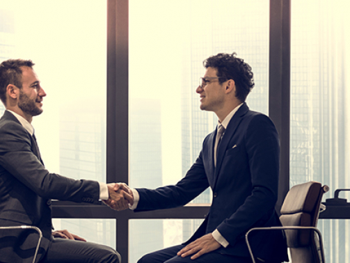 Businessman analyzing a wall with many financial charts and reports, he is underlining text with a marker