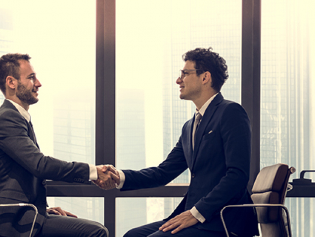 Businessman analyzing a wall with many financial charts and reports, he is underlining text with a marker